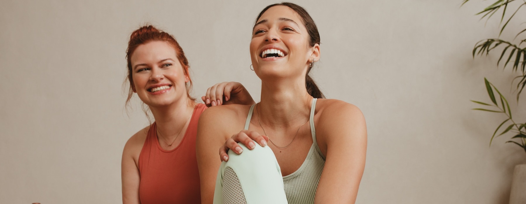 a couple of women sitting on a yoga mat